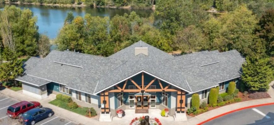 Lodges at Lake Salish external main building with a view of the surrounding trees, greenery, and lake.